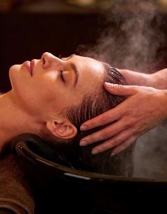 Professional head massage therapy session with hands working on client's head and neck